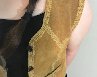 May include: A brown suede vest with a crocheted trim and button closure. The vest has a pocket on the left side.