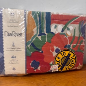 May include: A white ceramic mug with a black handle and the text "But First, Coffee" in a bold, black font. The mug is set against a neutral background, highlighting its simple design.