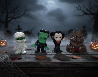May include: Four Halloween-themed figurines: a mummy, Frankenstein's monster, a vampire, and a werewolf. The figures are on a wooden surface with a spooky graveyard backdrop, lit pumpkins, and a spider web.