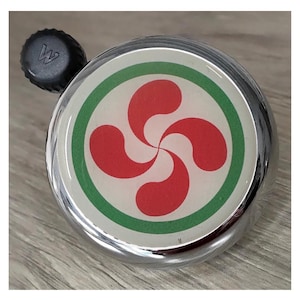 Peut inclure: Une sonnette de vélo argentée avec un autocollant circulaire rouge et vert représentant un trèfle à quatre feuilles rouge stylisé.