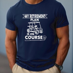 K&ouml;nnte beinhalten: Ein marineblaues T-Shirt mit einer wei&szlig;en Grafik eines Golfcarts und dem Text "My Retirement Plan Is On Course".