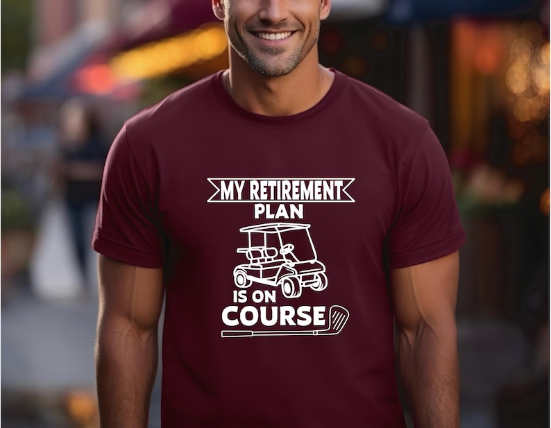 K&ouml;nnte beinhalten: Ein maroonfarbenes T-Shirt mit einer wei&szlig;en Grafik eines Golfwagens und dem Text "My Retirement Plan Is On Course".