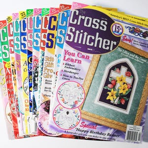 Peut inclure: Plusieurs magazines "The Cross Stitcher" aux couvertures colorées. Les couvertures présentent des motifs de point de croix, avec des textes comme "You Can Learn" et "Happy Birthday Banner". Les numéros sont de 20 à 25.