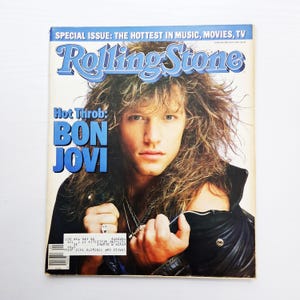 May include: A vintage Rolling Stone magazine cover featuring Bon Jovi. The cover has a blue banner with the text "SPECIAL ISSUE: THE HOTTEST IN MUSIC, MOVIES, TV" and the Rolling Stone logo. The headline reads "Hot Throb: BON JOVI".