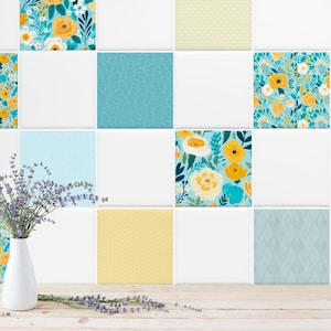 Könnte beinhalten: Ein Satz von 10 weißen Keramikfliesen mit einem blauen und gelben Blumenmuster. Die Fliesen sind in einem Raster angeordnet und zeigen verschiedene Blumenmotive.