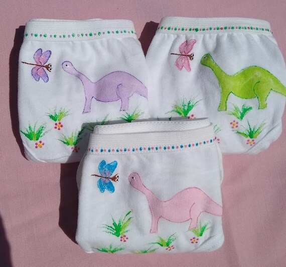A lot of children's underwear. Knitted baby clothes as a background.  Underwear in the form of panties and T-shirts for children. Delicate  clothes for girls and boys. Stock Photo