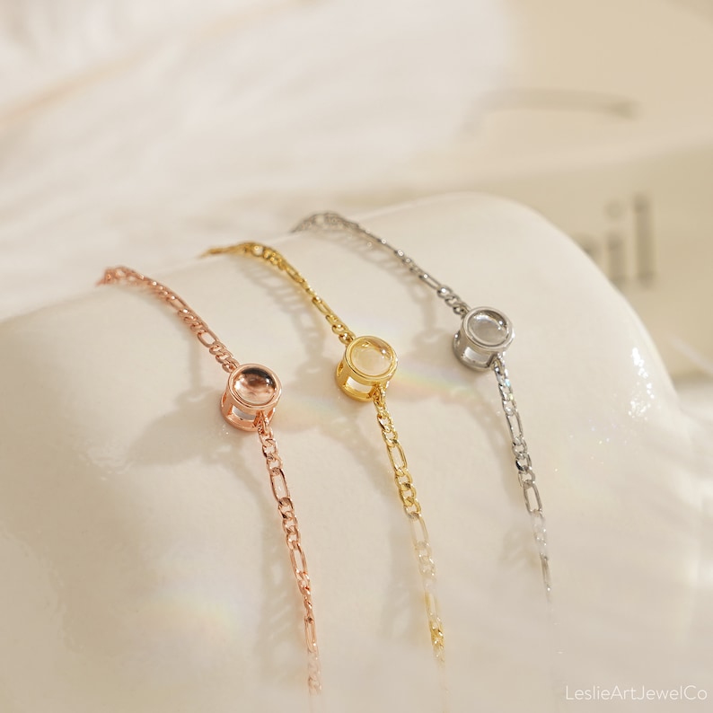 May include: Three delicate bracelets with a clear round stone charm. The bracelets are available in rose gold, gold, and silver.