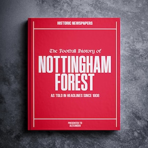 May include: A red book with the title "The Football History of Nottingham Forest" in white text. The book also has the text "Historic Newspapers" and "As told in headlines since 1908" in white text. The book is presented to Alexander.