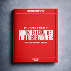 Puede incluir: Un libro rojo con el título "The Football History of Manchester United The Treble Winners As Told in Headlines 1998-99" y las palabras "Historic Newspapers" y "Presented to Andrew" en texto blanco.