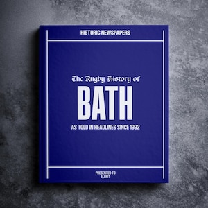 Könnte beinhalten: Ein blaues Buch mit weißem Text, der "HISTORIC NEWSPAPERS", "The Rugby History of BATH", "AS TOLD IN HEADLINES SINCE 1992" und "PRESENTED TO ELLIOT" lautet.