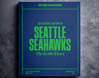 Może przedstawiać: Niebieska książka z tytułem "The Football History of Seattle Seahawks" w zielonym kolorze. Książka została wydana przez The Seattle Times i ma zieloną ramkę wokół tytułu. Podtytuł brzmi "As Told in Headlines Since 1974".