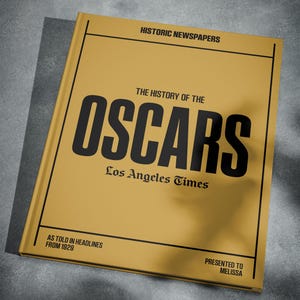Puede incluir: Un libro amarillo con el t&iacute;tulo "The History of the Oscars" en letras negras. El libro es del Los Angeles Times y presenta titulares de 1929. El libro se presenta a Melissa.