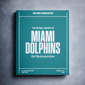 May include: A teal blue book with the title "The Football History of Miami Dolphins: The Washington Post" in white text. The book is subtitled "As Told in Headlines Since 1965" and "Presented to Liam".