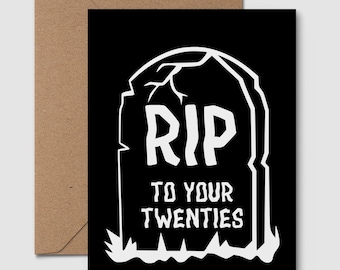 Puede incluir: Tarjeta de felicitación negra con un diseño de lápida blanca. La lápida dice "RIP TO YOUR TWENTIES" en letras mayúsculas. La tarjeta va acompañada de un sobre marrón.