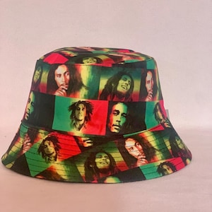 Peut inclure: Un chapeau bob noir avec un imprimé coloré du visage de Bob Marley. Le chapeau est de couleur verte, rouge et jaune.