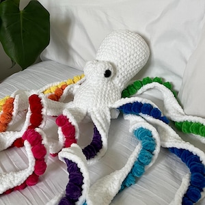 May include: White crocheted octopus plush toy with rainbow coloured pom-poms on each tentacle.