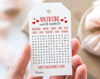 Op de afbeelding: Een wit cadeau-etiket met een rood hartontwerp en de tekst "VALENTINE word search". Het etiket bevat een woordzoeker met de woorden "VALENTINE, ARROW, CANDY, PINK, ROSE, HEART, LOVE, FLOWERS, CARD, FRIENDS". Het etiket bevat ook de tekst "HAPPY VALENTINE'S DAY!" en "From:"