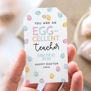Op de afbeelding: Een wit cadeau-etiket met een pastelkleurig paasei-patroon. De tekst luidt "You are an Egg-Cellent Teacher. Thanks for all you do! Happy Easter from:"