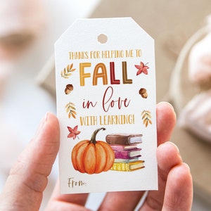 May include: A white gift tag with the text "Thanks for helping me to fall in love with learning!"  The tag features a watercolour illustration of a pumpkin, a stack of books, and autumn leaves.
