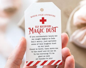 May include: A white tag with red and white candy cane stripes at the bottom. The tag says "NORTH POLE APPROVED" and has a red plus sign. The text "ELF RECOVERY MAGIC DUST" is in red and white. The tag has instructions for using the magic dust to help an elf recover.