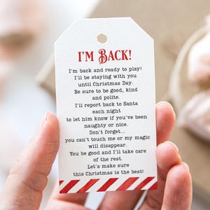 May include: A white gift tag with red and white striped edges. The tag has the text "I'M BACK!" in red letters and a poem about Father Christmas.