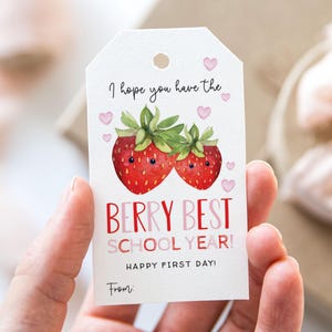 Könnte beinhalten: Ein weißes Etikett mit einer Aquarellillustration von zwei roten Erdbeeren mit grünen Blättern. Auf dem Etikett steht "I hope you have the BERRY BEST SCHOOL YEAR! HAPPY FIRST DAY!" mit Platz für eine "From:"-Notiz.