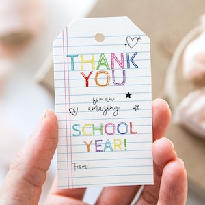 May include: A colorful thank you tag with the words "Thank You" in rainbow letters, "for an amazing school year!" in black letters, and a space for a name at the bottom. The tag is designed to look like a piece of notebook paper with lines.
