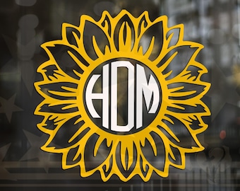 Könnte beinhalten: Ein gelbes, sonnenblumenförmiges Monogramm mit weißem Zentrum. Das Monogramm zeigt die Buchstaben "HDM" in einer fetten, serifenlosen Schrift. Die Sonnenblume hat detaillierte Blütenblatt-Ausschnitte, die ein dekoratives Design erzeugen.