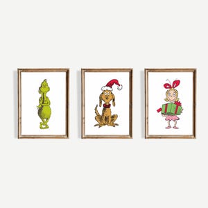 Peut inclure: Ensemble de trois impressions d'art encadrées représentant des personnages d'une histoire de Noël. Les impressions incluent une créature verte, un chien portant un chapeau de Père Noël et une fille avec un cadeau. Les illustrations sont de style dessin animé, sur fond blanc.