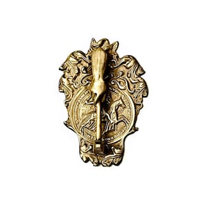 May include: An ornate brass door knocker featuring a horse head design. The knocker has a detailed relief of a horse and rider within a circular frame, surrounded by decorative scrollwork. The design is vintage and elegant.