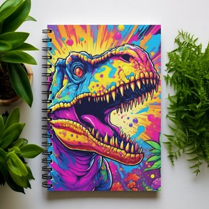 May include: A spiral bound notebook with a colorful graphic of a dinosaur's head with a bright yellow, blue, and pink paint splatter background.