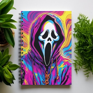 May include: A spiral bound notebook with a colorful abstract design featuring a white ghost mask with a black outline. The ghost mask is wearing a pink, blue, and yellow hoodie.
