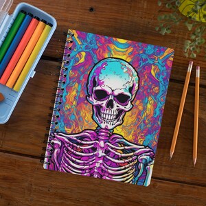 May include: A spiral bound notebook with a colourful psychedelic design featuring a white skull and skeleton. The background is a mix of blue, purple, yellow, and orange.