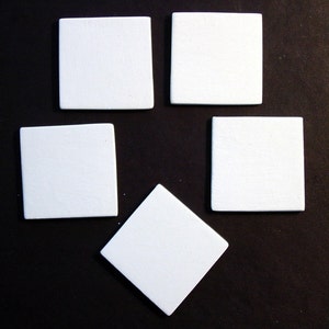 May include: Five white square tiles arranged in a diamond shape on a black background.