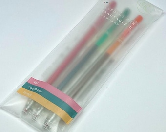 May include: A clear plastic package containing four retractable ballpoint pens. The pens are red, deep green, and orange. The package has a label with the words "Red", "Deep Green", and "Orange". The pens are 0.5 mm.