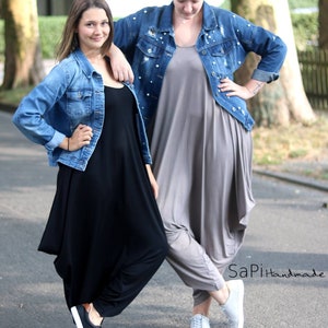 以下が含まれることがあります： カジュアルな服装の女性2人。一人はデニムジャケットと黒いドレス、もう一人はデニムジャケットとグレーのジャンプスーツを着ています。どちらもスニーカーを履いています。ジャケットにはパールのアクセントが付いています。