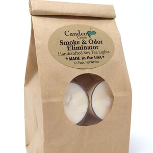 May include: A brown paper bag with a window showing two white tea lights. The bag has a label that reads "Candeo Candle Smoke & Odor Eliminator Handcrafted Soy Tea Lights * MADE in the USA * 12-Pack, Net Wt 6oz"