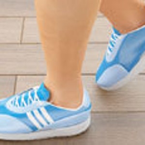 May include: Light blue athletic shoes with white accents and laces. The shoes have a white sole and are designed for running or walking. The image shows the shoes on a person's feet, with one foot in mid-stride.