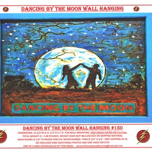 May include: A wooden wall hanging with a blue background and a large full moon. Two figures are dancing in front of the moon. The text "Dancing by the Moon" is written in green and white letters on the bottom of the piece. The piece is 12 3/4 inches wide, 11 1/2 inches high, and 1 inch deep.