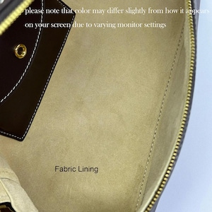 May include: Inside view of a brown leather bag with a beige fabric lining. The text "Fabric Lining" is printed on the lining.