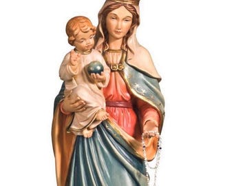 Op de afbeelding: Een religieus beeld van een vrouw met een kroon die een kind vasthoudt. De vrouw draagt een blauwe en rode jurk en het kind houdt een wereldbol vast. Een rozenkrans hangt uit haar hand. Het beeld heeft gouden accenten.