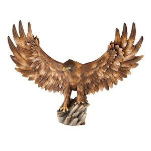 Op de afbeelding: Een gedetailleerd bruin adelaarsbeeld met uitgespreide vleugels, geplaatst op een rotsachtige basis. De sculptuur heeft ingewikkelde veerdetaillering en een gele snavel, wat een majestueuze roofvogel laat zien. De spanwijdte is ongeveer 61 cm.