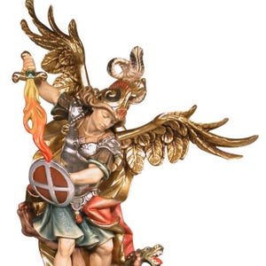 Può includere: Statua dettagliata di San Michele Arcangelo, raffigurato con ali dorate, una spada fiammeggiante e uno scudo. La figura, in armatura, è in piedi sopra un drago sconfitto. La statua ha una finitura dettagliata e dipinta a mano.