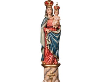 Op de afbeelding: Een gesneden houten beeld van de Maagd Maria met het kindje Jezus, beiden gekroond. Maria draagt een rode jurk, een blauwe mantel en een groene sjaal. Het beeld is gemonteerd op een decoratieve zuil met een gouden ster.