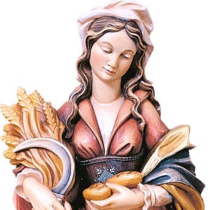 statue of saint notburga, wooden sculpture from Val Gardena. The statue is carved in maple wood and hand painted