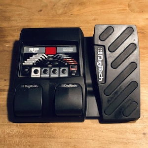 May include: Black Digitech RP multi-effects guitar pedal with two large foot pedals and a control panel with the text "RP Multi-Effects Processor" and "Digitech".