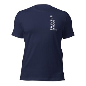 Può includere: T-shirt blu navy con la scritta bianca verticale "FOCUS BREATHE EXECUTE". La maglietta ha maniche corte e girocollo. Il tessuto sembra morbido e confortevole.