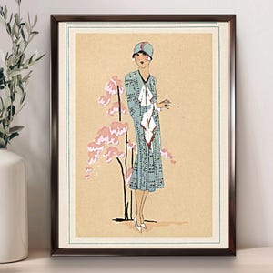 1920s Art Deco fashion illustration from Tres Parisien magazine showing a stylish woman in powder blue dress with white tie collar and matching cloche hat, standing beside pink cherry blossoms. Digital wall art from French vintage fashion publication.
