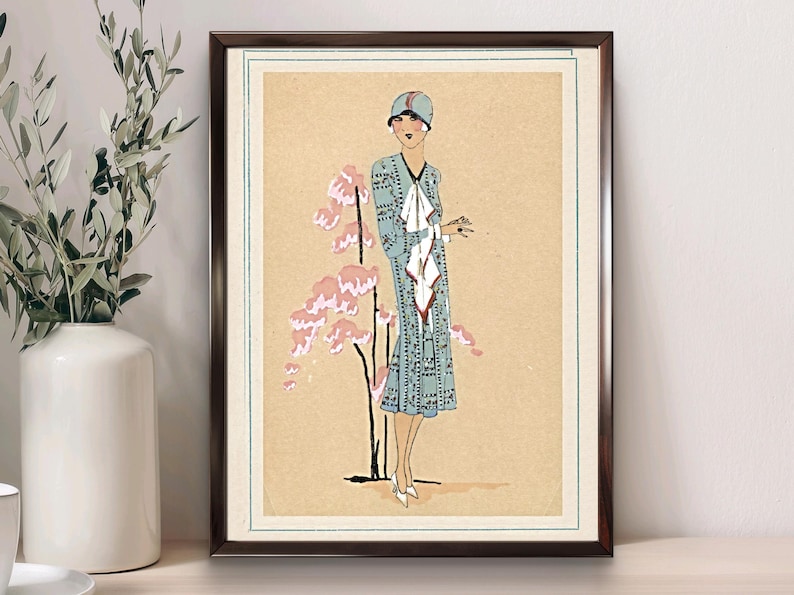 1920s Art Deco fashion illustration from Tres Parisien magazine showing a stylish woman in powder blue dress with white tie collar and matching cloche hat, standing beside pink cherry blossoms. Digital wall art from French vintage fashion publication.