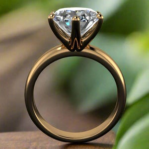 May include: A gold engagement ring with a large, clear, round diamond set in a four-prong setting.